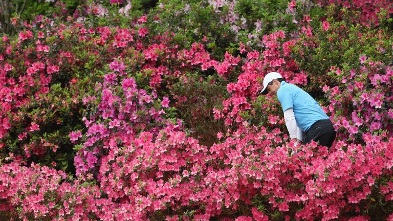 Rory McIlroy plays a shot out of the azaleas on the 13th hole during the third round of the 2018 Masters Tournament at Augusta National Golf Club 