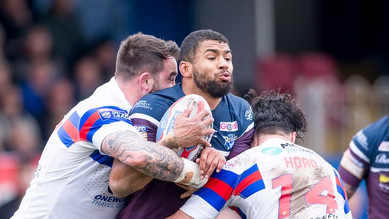 Watkins is tackled by Wakefield's Craig Huby and Justin Horo