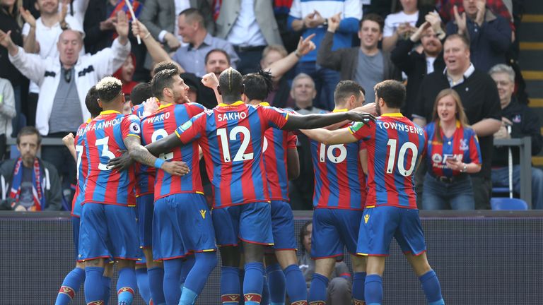 Wilfried Zaha (obscured) celebrates with teammates after scoring Crystal Palace's first goal of the game against Brighton and Hove Albion at Selhurst Park