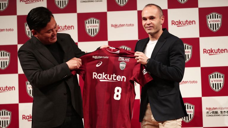 Andres Iniesta and Hiroshi Mikitani, owner of Rakuten and Vissel Kobe club, hold the team's jersey during a press conference in Tokyo on May 24, 2018