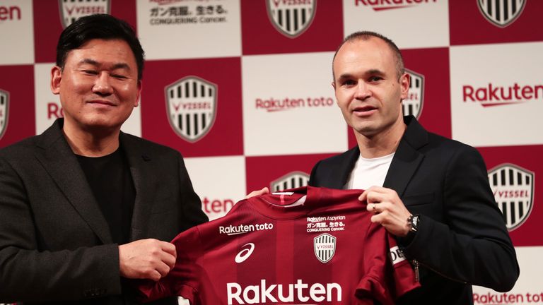 Andres Iniesta and Hiroshi Mikitani, owner of Rakuten and Vissel Kobe club, hold the team's jersey during a press conference in Tokyo on May 24, 2018