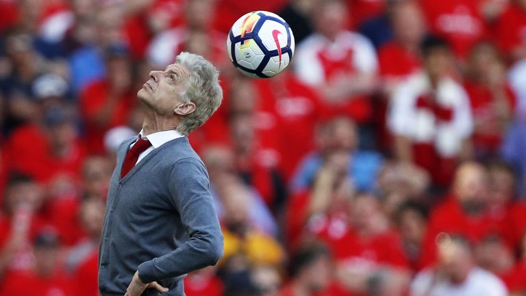 Arsene Wenger heads the ball back into play after it is returned from the crowd