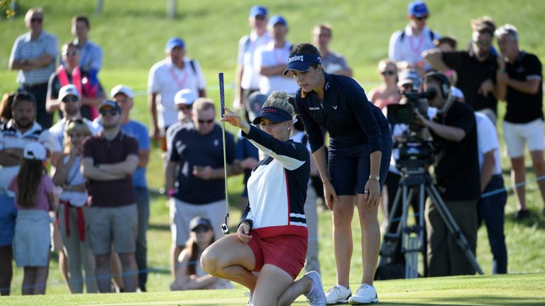 Charley Hull of England Women lines up a putt on the fifth green at the GolfSixes as Georgia Hall looks on