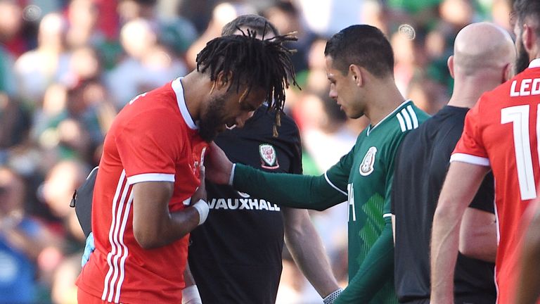 Ashley Williams is consoled by Javier Hernandez after suffering  rib injury against Mexico