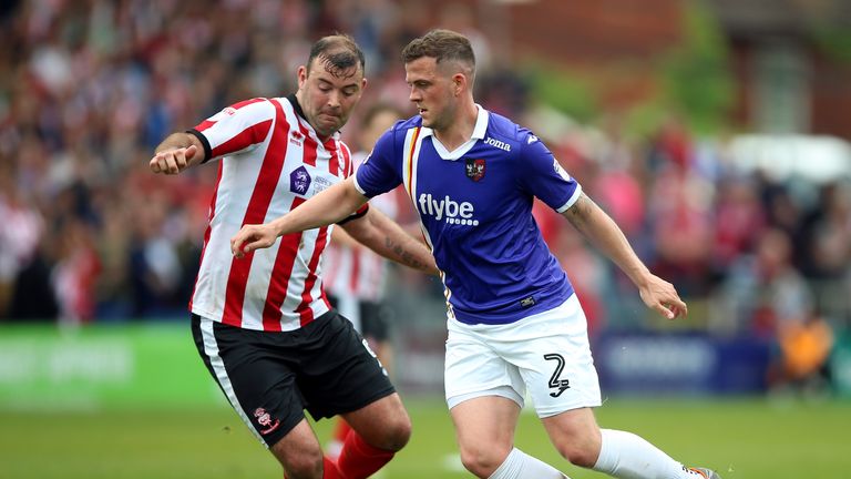 Exeter City&#39;s Pierce Sweeney (right) and Lincoln City&#39;s Matt Rhead battle for the ball 