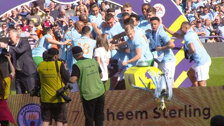 Manchester City's players accidentaly knock the Premier League trophy off the podium before they receive it.