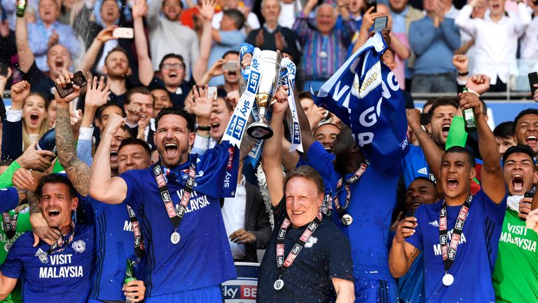 Sean Morrison lifts the trophy with Neil Warnock as Cardiff City celebrate gaining promotion to the Premier League