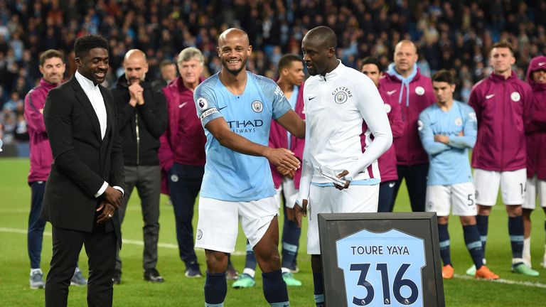 Yaya Toure is presented with gifts by Man City captain Vincent Kompany after his final home game for the club