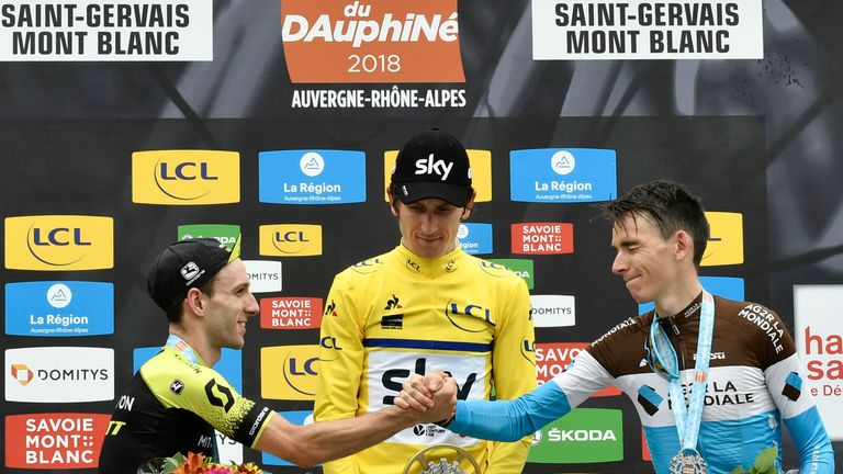 Stage winner and overall second-placed Great Britain's Adam Yates (L) and third-placed France's Romain Bardet (R) tap hands as they celebrate on the podium with overall race winner Britain's Geraint Thomas, wearing the overall leader's yellow jersey, after the seventh and last stage of the 70th edition of the Criterium du Dauphine cycling race between Moutiers and Saint-Gervais Mont-Blanc on June 10, 2018