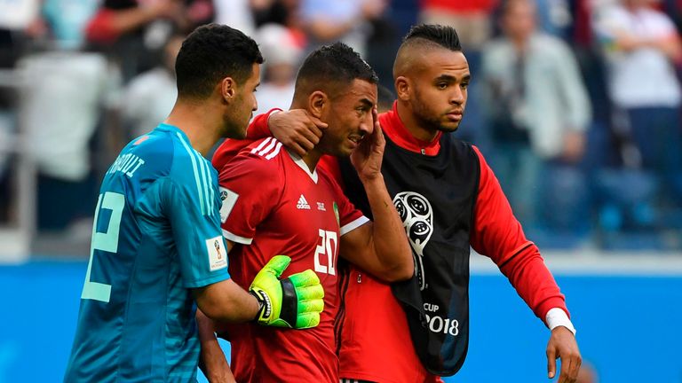 Aziz Bouhaddouz (C) is consoled by teammates after his own goal handed Iran all three points in Group B