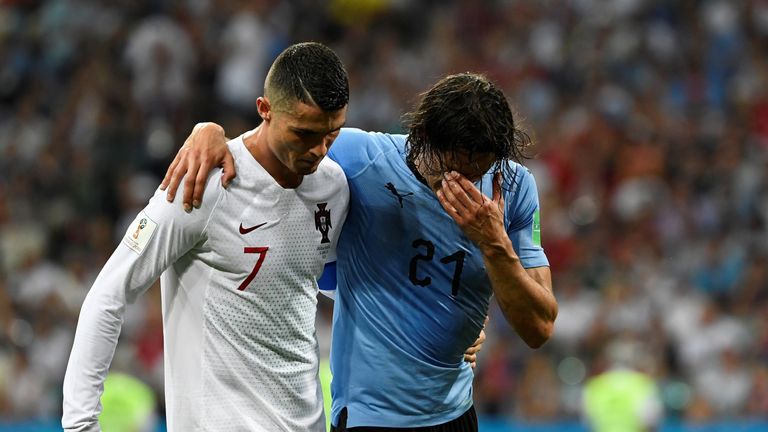 Cristiano Ronaldo helps an injured Edinson Cavani from the field