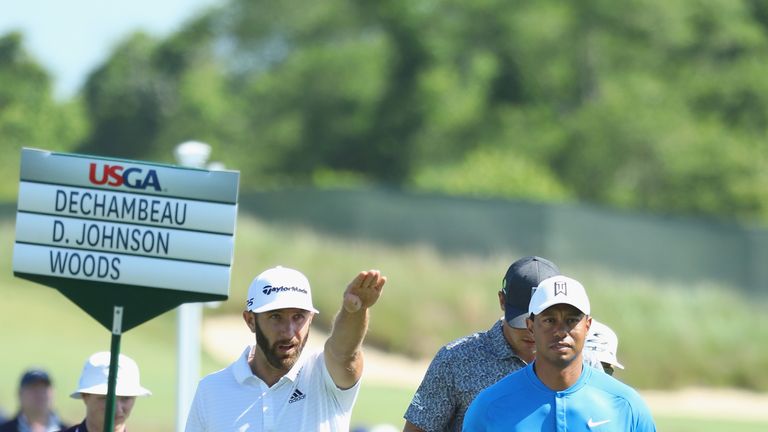 Dustin Johnson of the United States and Tiger Woods of the United States walk up the eighth hole during a practice round prior to the 2018 U.S. Open at Shinnecock Hills Golf Club on June 12, 2018 in Southampton, New York