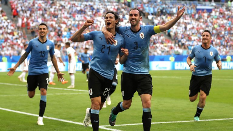 Edinson Cavani celebrates with team-mate Diego Godin after scoring Uruguay's third goal