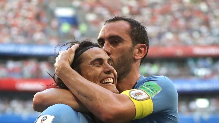 Edinson Cavani celebrates with team-mate Diego Godin after scoring Uruguay's third goal
