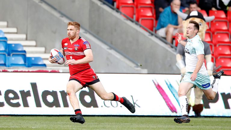 Salford Red Devils' Kris Welham breaks away from Widnes Vikings Tom Gilmore to score a try