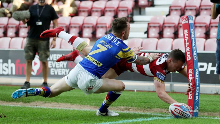 Liam Marshall of Wigan Warriors scores the first try against Leeds