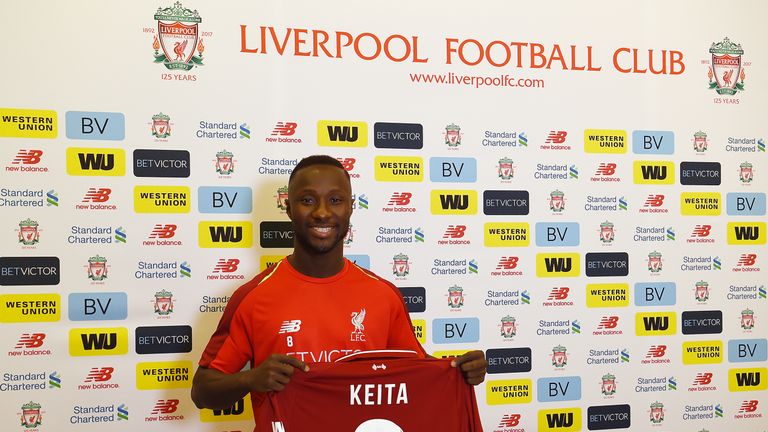 Naby Keita poses with the No.8 shirt at the club&#39;s Melwood training ground
