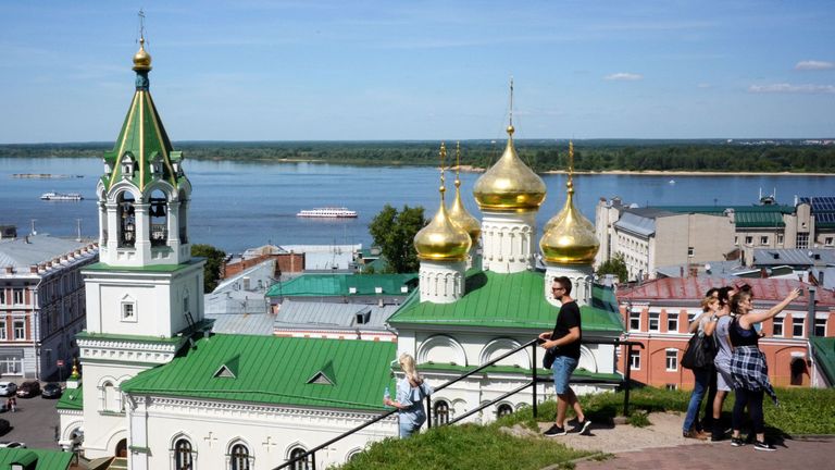 Tourists take pictures in front of the Volga river embankment in central Nizhny Novgorod