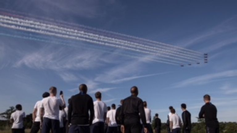 The Red Arrows fly over St George's Park as the England squad watch on 