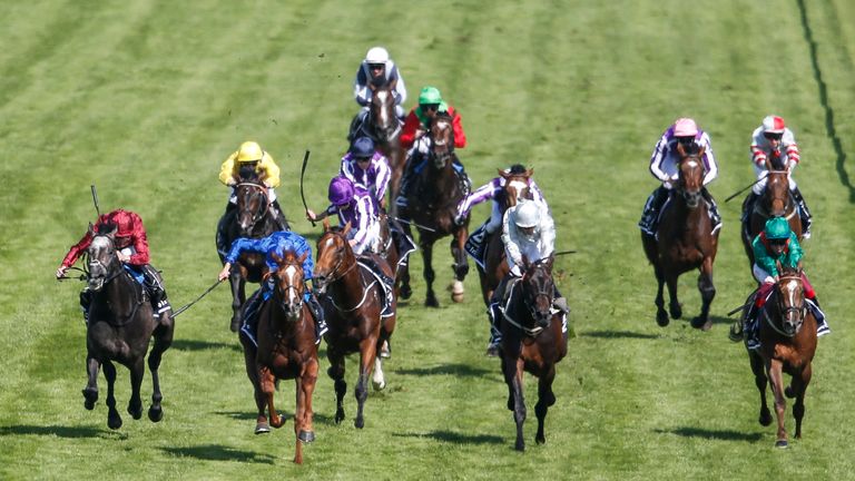 William Buick riding Masar (L, blue) wins the Investec Derby at Epsom 
