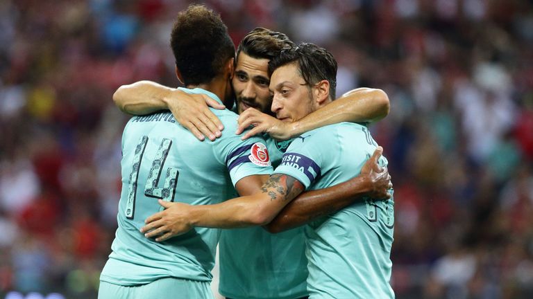 Arsenal players celebrate the opening goal in Singapore
