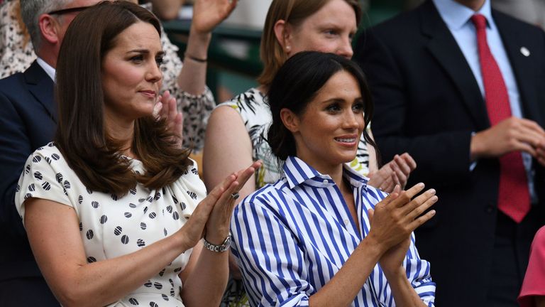 Catherine, Duchess of Cambridge, (L) and Meghan, Duchess of Sussex applaud as US player Serena Williams and Germany's Angelique Kerber arrive on court to play their women's final match on the twelfth day of the 2018 Wimbledon Championships at The All England Lawn Tennis Club in Wimbledon