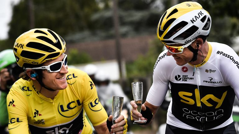 Geraint Thomas and Chris Froome share a glass of champagne on the ride into Paris