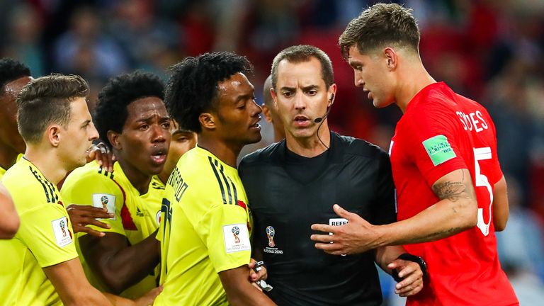 John Stones and Juan Cuadrado have to be separated by referee Mark Geiger during England's last 16 match against Colombia