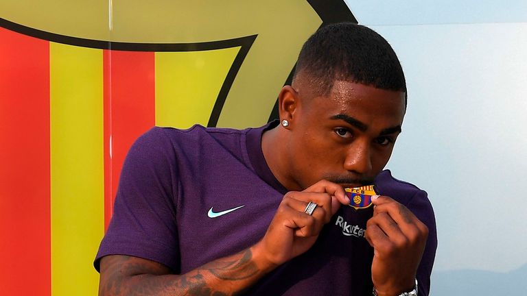 Barcelona's new signing Malcom kisses the club badge during his unveiling at the Camp Nou on July 24, 2018
