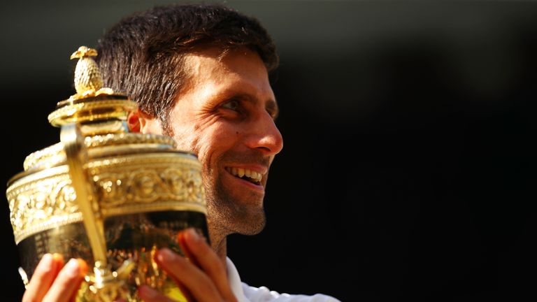 Novak Djokovic of Serbia celebrates with the trophy after winning the Men's Singles final against Kevin Anderson of South Africa on day thirteen of the Wimbledon Lawn Tennis Championships at All England Lawn Tennis and Croquet Club on July 15, 2018 in London, England.