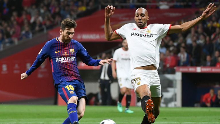 Steven N'Zonzi of Sevilla attempts to dispossess Barcelona's Lionel Messi