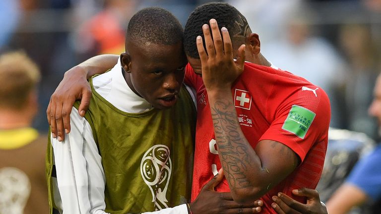 Switzerland's midfielder Gelson Fernandes (L) comforts defender Manuel Akanji after the team lost the Russia 2018 World Cup round of 16 football match between Sweden and Switzerland at the Saint Petersburg Stadium in Saint Petersburg on July 3, 2018