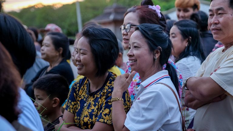 Onlookers watch and cheer as ambulances transport rescued boys in Thailand