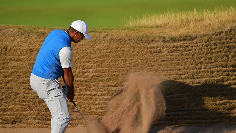 Tiger Woods play a bunker shot at the 14th where he could only make a five