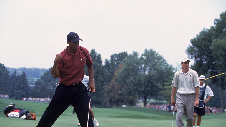 Tiger Woods sinks his putt as Jim Furyk looks on during the NEC Invitational at the Firestone Country Club in Akron,