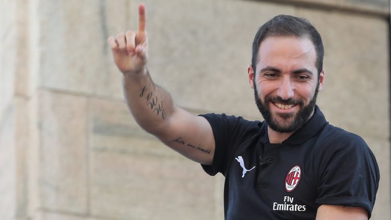 Gonzalo Higuain waves to fans from a balcony in Milan