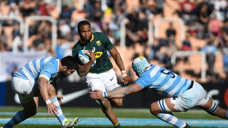 South Africa's Aphiwe Dyantyi (C) is tackled by Argentina's Nahuel Tetaz Chaparro (left) and Tomas Lavanini (second left) 