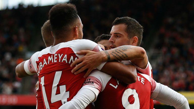 Arsenal players celebrate with Arsenal&#39;s French striker Alexandre Lacazette (R) after an own goal from a Lacazette cross gave Arsenal their second goal during the English Premier League football match between Arsenal and West Ham United at the Emirates Stadium in London on August 25, 2018.