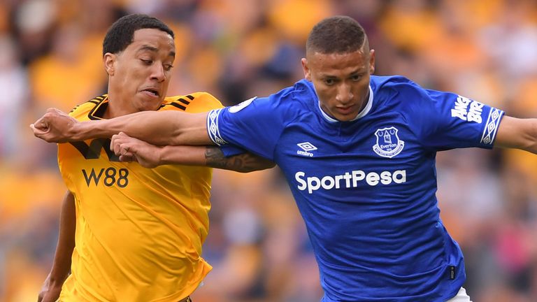 Everton's Richarlison tussles with a Wolves player.