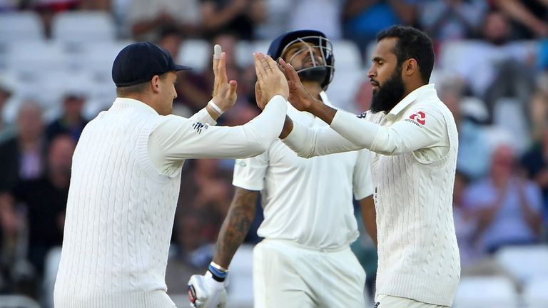 India's Shikhar Dhawan (C) reacts after losing his wicket to England's Adil Rashid (R) during play on the second day of the third Test cricket match between England and India at Trent Bridge in Nottingham,