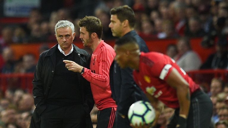 Manchester United manager Jose Mourinho speaks with first-team coach Michael Carrick during the match against Tottenham
