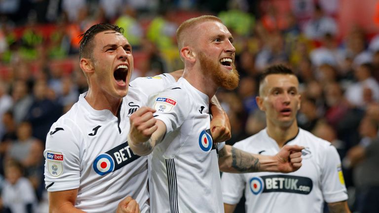 Oli McBurnie of Swansea City (C) celebrates his opening goal with team-mate Connor Roberts during the Sky Bet Championship match between Swansea City and Leeds United at the Liberty Stadium