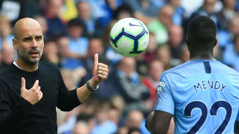 Manchester City's Spanish manager Pep Guardiola (L) throws the ball to Manchester City's French defender Benjamin Mendy (R) during the English Premier League football match between Manchester City and Huddersfield Town at the Etihad Stadium in Manchester, north west England, on August 19, 2018