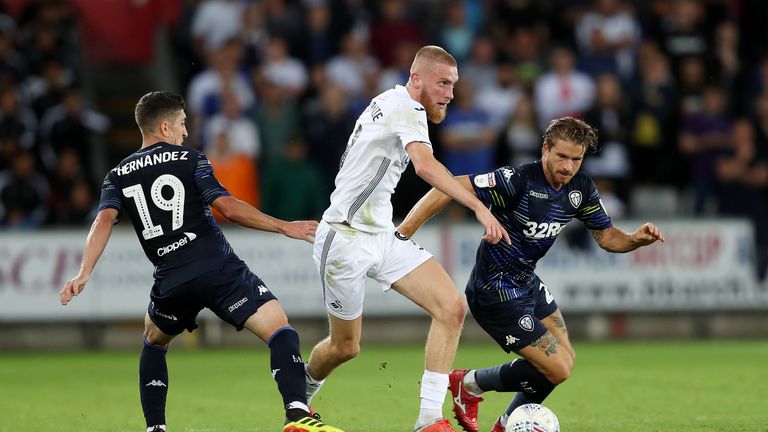 Swansea City's Oli McBurnie gets away from Leeds Pablo Hernandez and Gaetano Berardi during the Sky Bet Championship match at the Liberty Stadium, Swansea. PRESS ASSOCIATION Photo. Picture date: Tuesday August 21, 2018. See PA story SOCCER Swansea. Photo credit should read: David Davies/PA Wire. RESTRICTIONS: EDITORIAL USE ONLY No use with unauthorised audio, video, data, fixture lists, club/league logos or "live" services. Online in-match use limited to 120 images, no video emulation. No use in betting, games or single club/league/player publications.