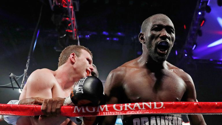 Terence Crawford (R) celebrates his ninth-round TKO victory over Jeff Horn (L) who is held by referee Robert Byrd at the end of their WBO welterweight title fight.
