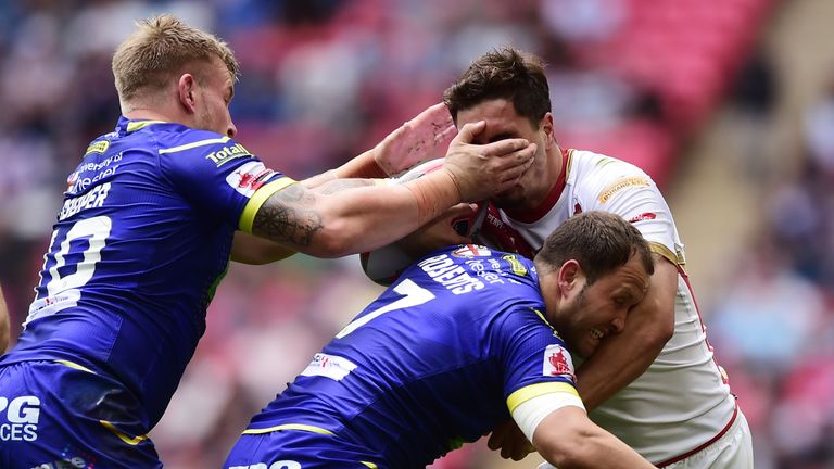 Lance Todd trophy winner Tony Gigot is tackled by Mike Cooper and Tyrone Roberts of Warrington Wolves