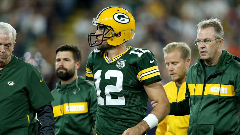 Aaron Rodgers leaves the field to have his knee assessed against Chicago