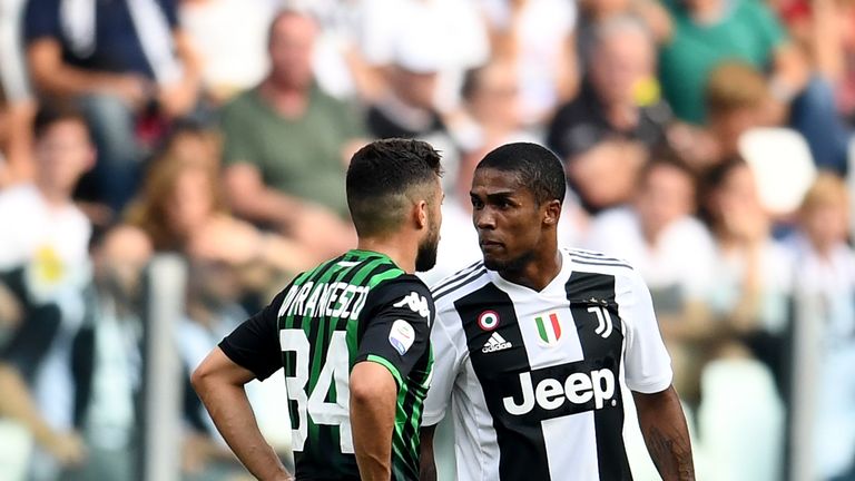 Douglas Costa of Juventus (R) spits to Federico Di Francesco of Sassuolo during the serie A match between Juventus and US Sassuolo at Allianz Stadium on September 16, 2018 in Turin, Italy.
