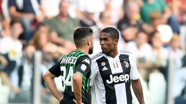 Douglas Costa of Juventus (R) spits at Federico Di Francesco of Sassuolo during the Serie A match between Juventus and US Sassuolo at Allianz Stadium on September 16, 2018 in Turin, Italy