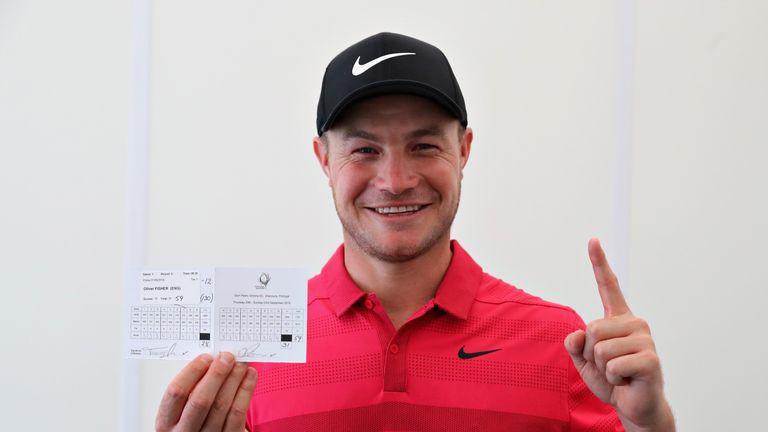 Oliver Fisher celebrates with his scorecard after carding the first round of 59 in European Tour history